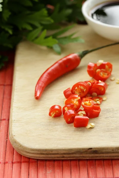 Fresh red chili peppers on a wooden board — Stock Photo, Image