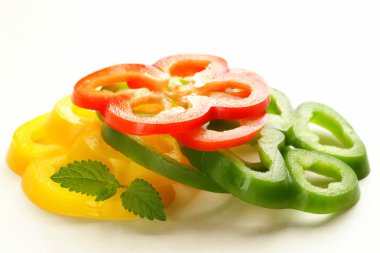 beyaz zemin üzerine kırmızı, sarı ve yeşil biber dilimlenmiş