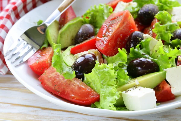 Средиземноморский салат с черными оливками, салатом, сыром и помидорами — стоковое фото