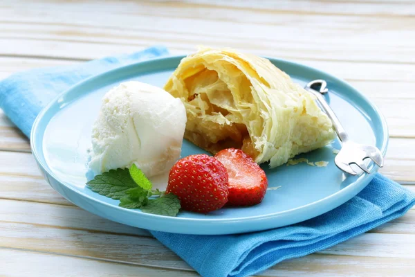 Strudel de pomme traditionnel avec des raisins secs, servi avec une cuillère de crème glacée — Photo