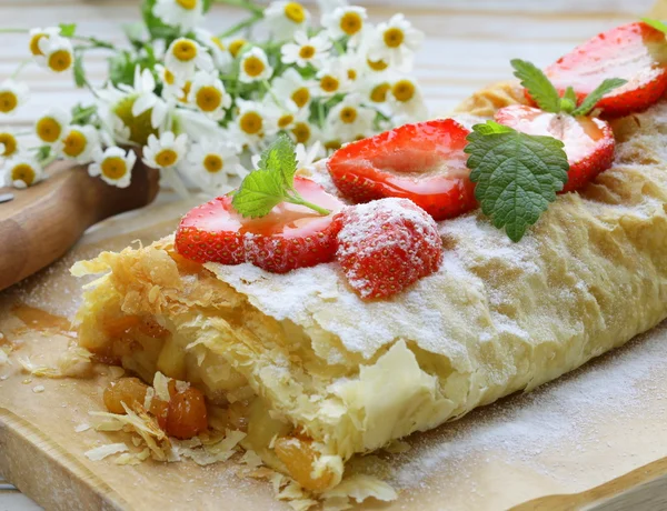 Traditionele Apfelstrudel met rozijnen, geserveerd op een houten bord — Stockfoto