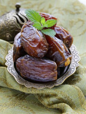 ahşap bir masa üzerinde bir kapta tarihleri tatlı kurutulmuş