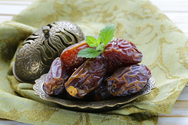 Sweet dried dates in bowl on a wooden table — Stock Photo, Image
