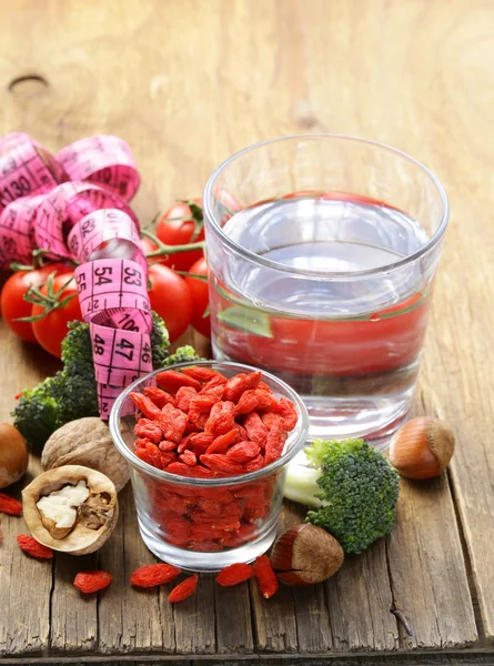 Water, noten, gedroogde goji bessen en verse groenten voor een gezond dieet — Stockfoto
