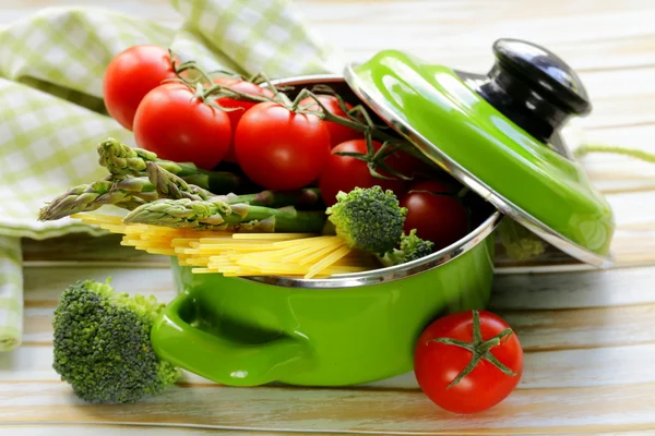 Zöld edények tele zöldségfélék (paradicsom, spárga, gomba, brokkoli) és tészta — Stock Fotó