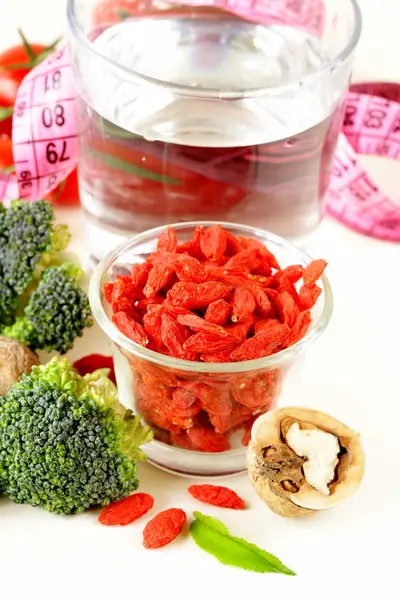 Torkade goji bär, vatten, nötter och färska grönsaker för en hälsosam diet — Stockfoto