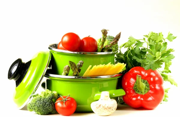 Gröna krukor fulla av grönsaker (tomater, sparris, champinjoner, broccoli) och pasta — Stockfoto