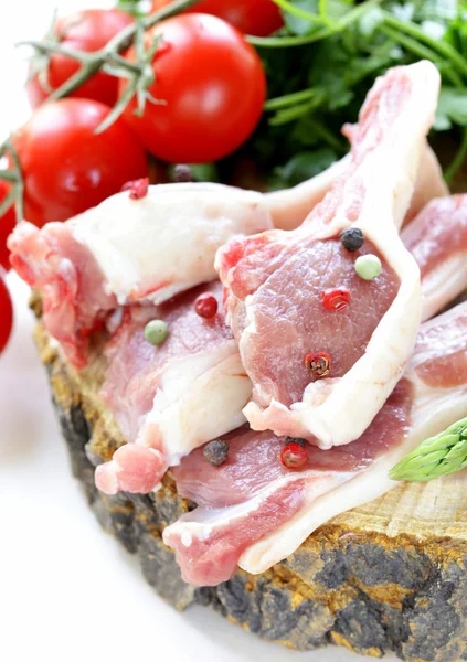 Çiğ et, ahşap tahta üzerinde sebzeli Kuzu pirzola — Stok fotoğraf