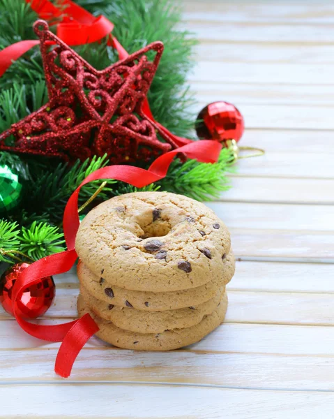 与圣诞树枝和装饰的木制背景上的巧克力饼干 — 图库照片