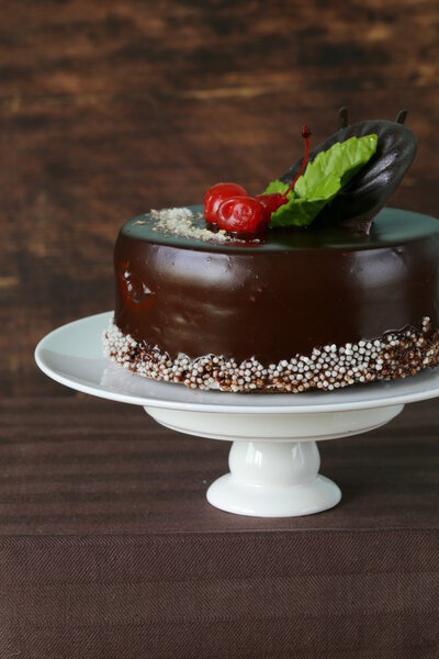 Праздничный красивый шоколадный торт с глазурью и вишней
