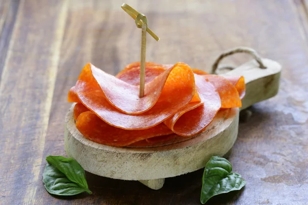 Salsicha de pepperoni picante saborosa em uma placa de madeira — Fotografia de Stock