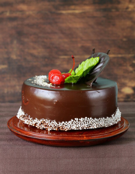 Праздничный красивый шоколадный торт с глазурью и вишней
