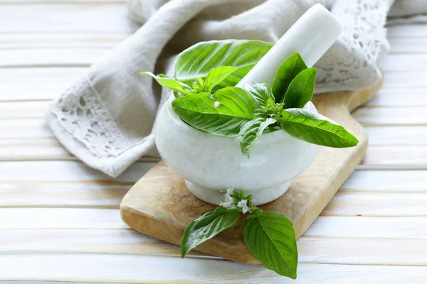 Fresh green basil leaves in a marble mortar — Stock Photo, Image