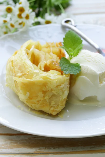Traditionele Apfelstrudel met rozijnen, geserveerd met een bolletje ijs — Stockfoto
