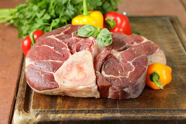 Carne crua fresca ossobuco em uma placa de madeira — Fotografia de Stock