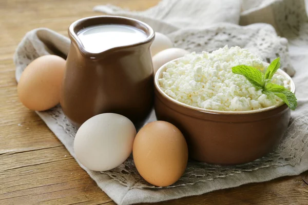 Productos rústicos requesón, leche y huevos en una mesa de madera — Foto de Stock