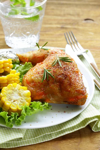 Baked chicken leg with corn for garnish — Stock Photo, Image