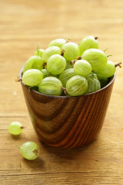 Fresh ripe green gooseberries on wooden table — Stock Photo, Image