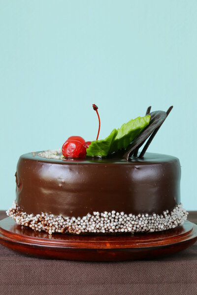 Праздничный красивый шоколадный торт с глазурью и вишней

