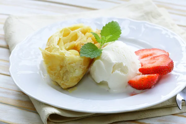 Strudel de pomme traditionnel avec des raisins secs, servi avec une cuillère de crème glacée — Photo