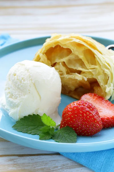 Traditional apple strudel with raisins, served with a scoop of ice cream — Stock Photo, Image