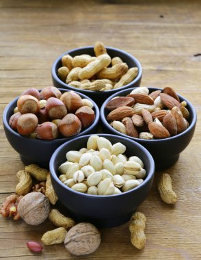 Kuruyemiş (badem, ceviz, fındık, fıstık) ahşap bir masa üzerinde bir kase çeşitleri