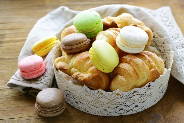 Pasteles tradicionales franceses croissants y macarrones en una canasta de encaje —  Fotos de Stock