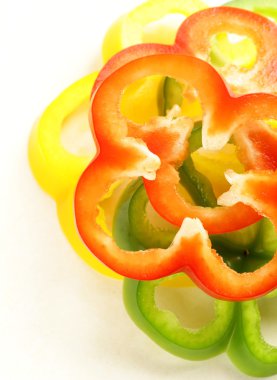 beyaz zemin üzerine kırmızı, sarı ve yeşil biber dilimlenmiş