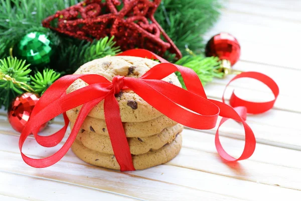 Biscoitos com chocolate em um fundo de madeira com galhos de árvore de Natal e decorações — Fotografia de Stock