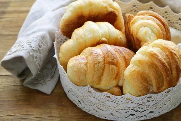 Croissants à pâte feuilletée à la française traditionnelle dans un panier en dentelle — Photo