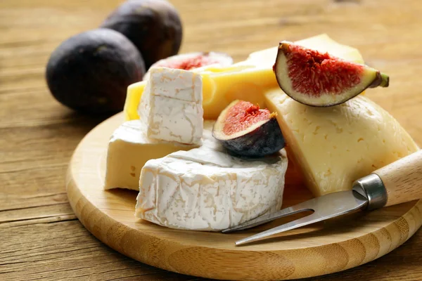 Cheeseboard with maasdam, camembert, cheddar cheese and figs — Stock Photo, Image