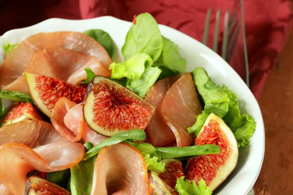 Салат с копченой ветчиной и свежими сладкими инжирами — стоковое фото