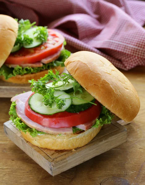 Hamburger snack con verdure fresche e prosciutto su una tavola di legno — Foto Stock