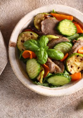 Kızarmış sebzeli salata ve biftek.