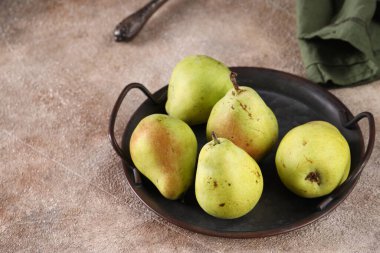 Masanın üzerinde taze armutlar var.