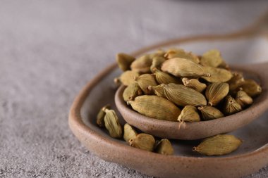 organic spice cardamom in a ceramic spoon