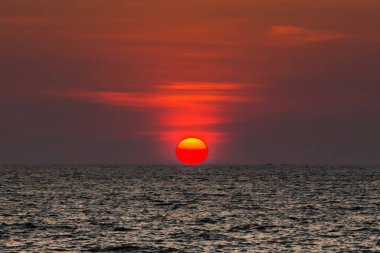 Sahilde gün batımının muhteşem manzarası. Denizde ve turuncu gökyüzünde, Tayland.