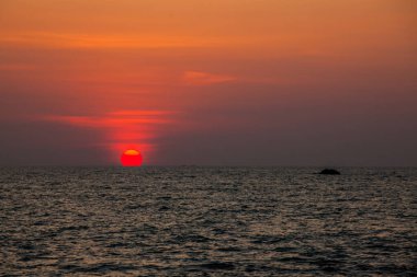 Sahilde gün batımının muhteşem manzarası. Denizde ve turuncu gökyüzünde, Tayland.