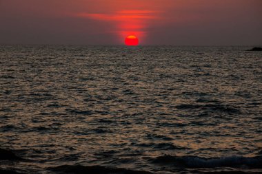 Sahilde gün batımının muhteşem manzarası. Denizde ve turuncu gökyüzünde, Tayland.