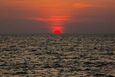 Sahilde gün batımının muhteşem manzarası. Denizde ve turuncu gökyüzünde, Tayland.