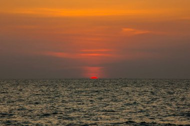 Sahilde gün batımının muhteşem manzarası. Denizde ve turuncu gökyüzünde, Tayland.