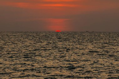 Sahilde gün batımının muhteşem manzarası. Denizde ve turuncu gökyüzünde, Tayland.