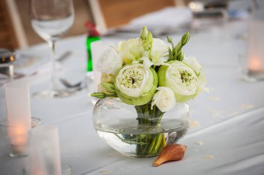 Hoş geldin konuğu için ziyafet masasında bir çiçek.