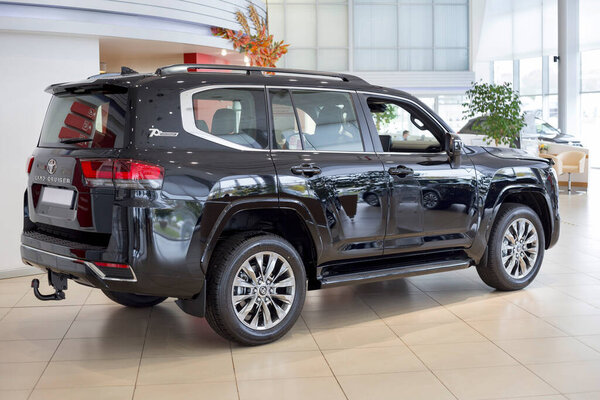 Россия, Ижевск - 30 сентября 2021 года: выставочный зал Toyota. Новый современный внедорожник Land Cruiser 300 в салоне дилеров. Вид сбоку и сзади. Известный мировой бренд. Современный транспорт.