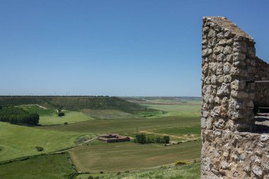 Güneşli bir bahar gününde, ortaçağ duvarlarının üzerindeki Castillian çayırlarının manzarası.