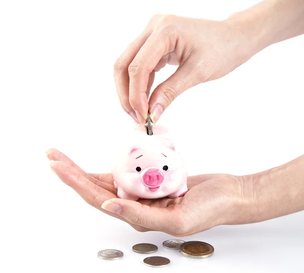 Hand geld steken in een piggy bank Rechtenvrije Stockfoto's