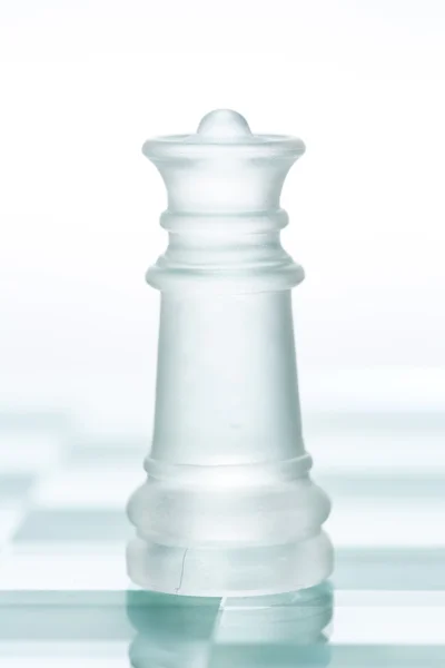 Reina de ajedrez de vidrio está de pie a bordo, cortado de respaldo blanco — Foto de Stock
