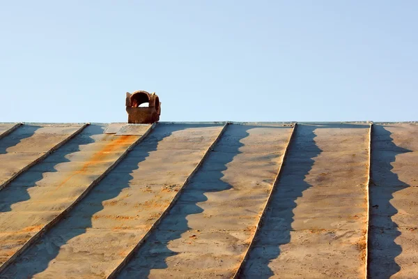 Chimney on an obsolete tinny roof — Stock Photo, Image