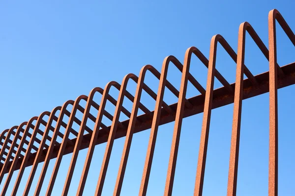 Металлический забор с изогнутыми стержнями — стоковое фото