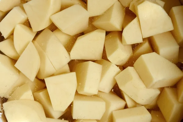 Die gewürfelten Kartoffelknollen in Wasser — Stockfoto